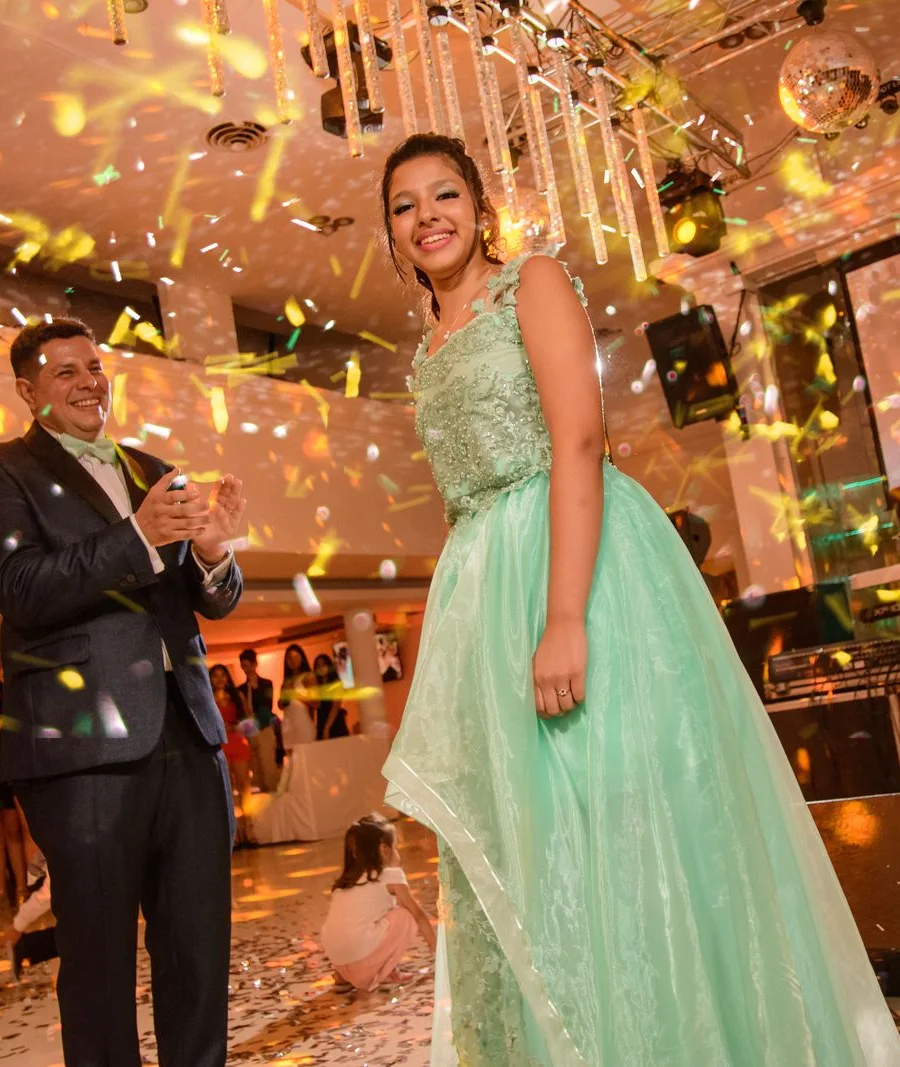 Pai aplaudindo a filha debutante na festa de quinze anos